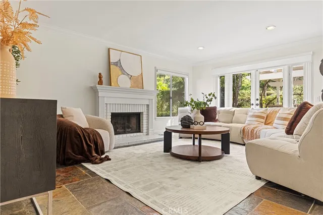 a living room with furniture a large window and a fireplace