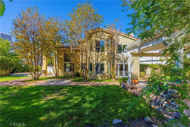 an aerial view of residential houses with outdoor space and trees
