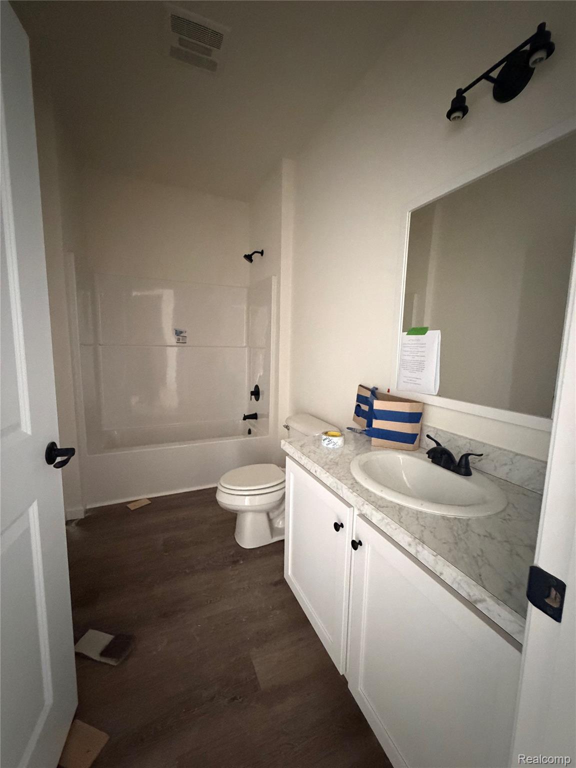 31450 Beverly Road Romulus, MI 48174 - Photo 7 of 10 White vanity with dual cabinet doors, light-toned countertop, and undermount sink