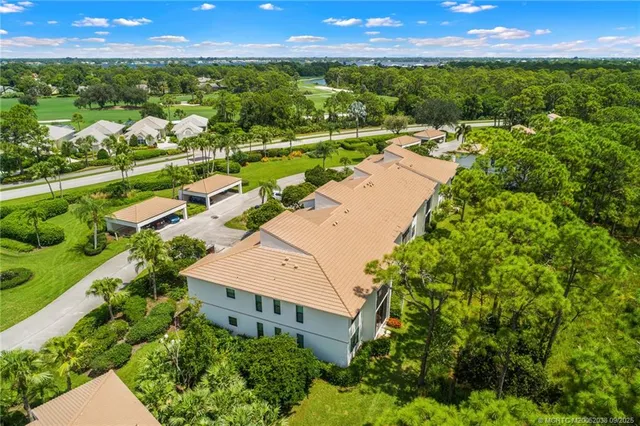 an aerial view of residential houses with outdoor space and trees