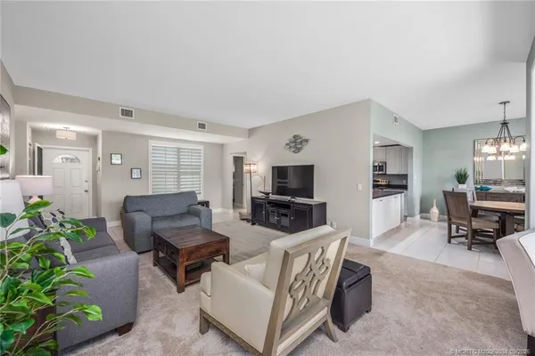 a living room with furniture a lamp and a flat screen tv