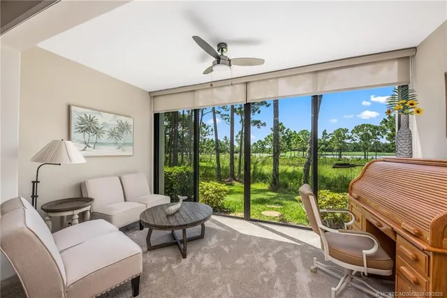 a living room with furniture and a floor to ceiling window