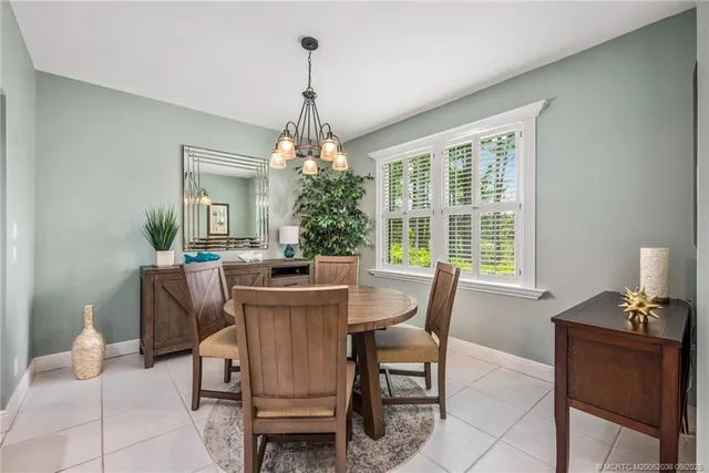 a dining room with furniture a chandelier and window