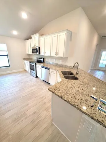 a kitchen with stainless steel appliances granite countertop a sink stove and cabinets