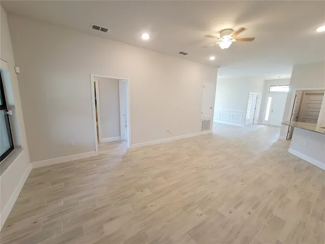 a view of a livingroom with a ceiling fan a fireplace and wooden floor