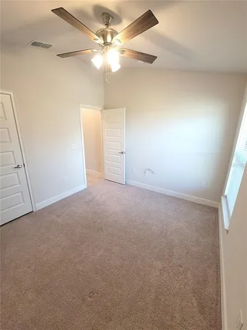 en empty room with windows and fan