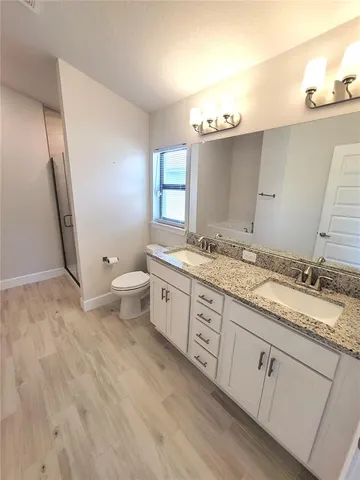 a bathroom with a granite countertop sink mirror and toilet