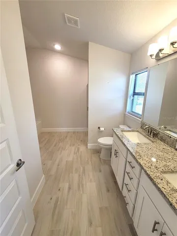 a bathroom with a granite countertop sink toilet and shower
