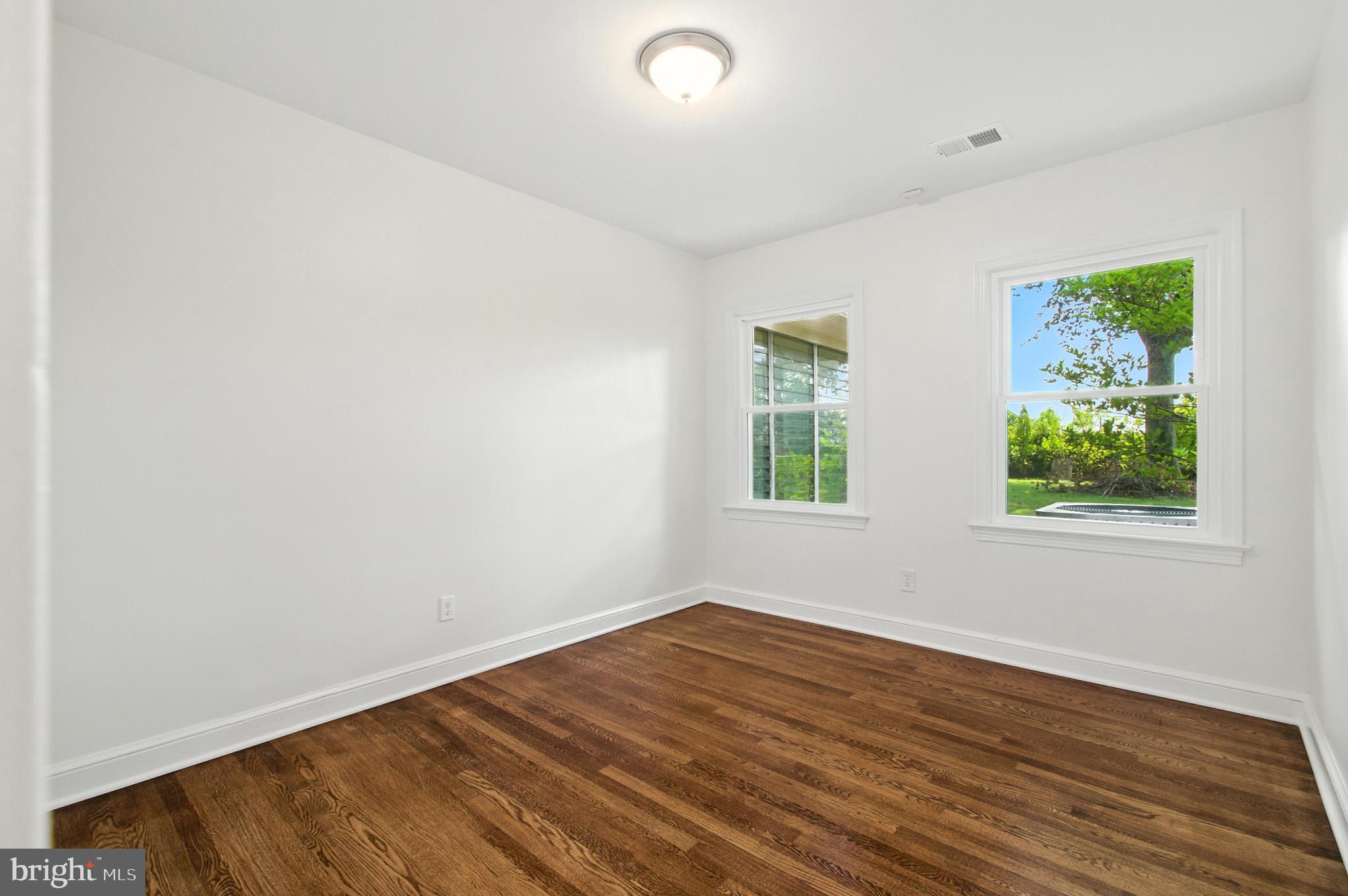 307 Plymouth Street Silver Spring, MD 20901 - Photo 21 of 44 an empty room with wooden floor and windows