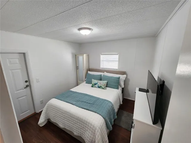 a bedroom with a bed and a flat screen tv