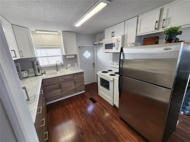 a kitchen with stainless steel appliances a stove a sink and a refrigerator