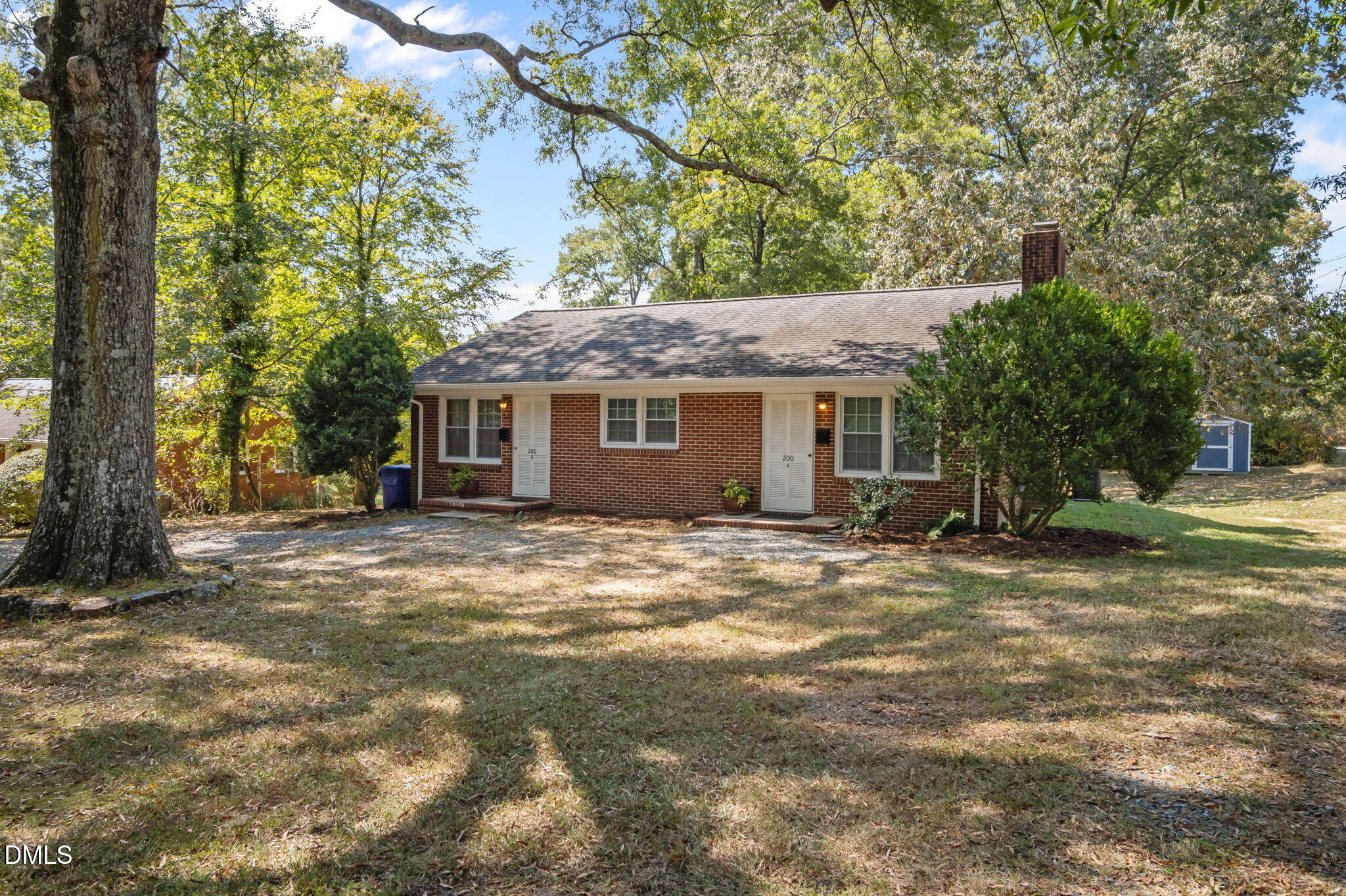 a view of a house with a yard and large tree