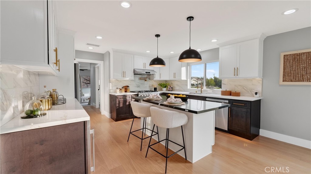 4404 Cogswell Road El Monte, CA 91732 - Photo 20 of 63 a kitchen with kitchen island granite countertop a sink a stove a refrigerator and island with wooden floor