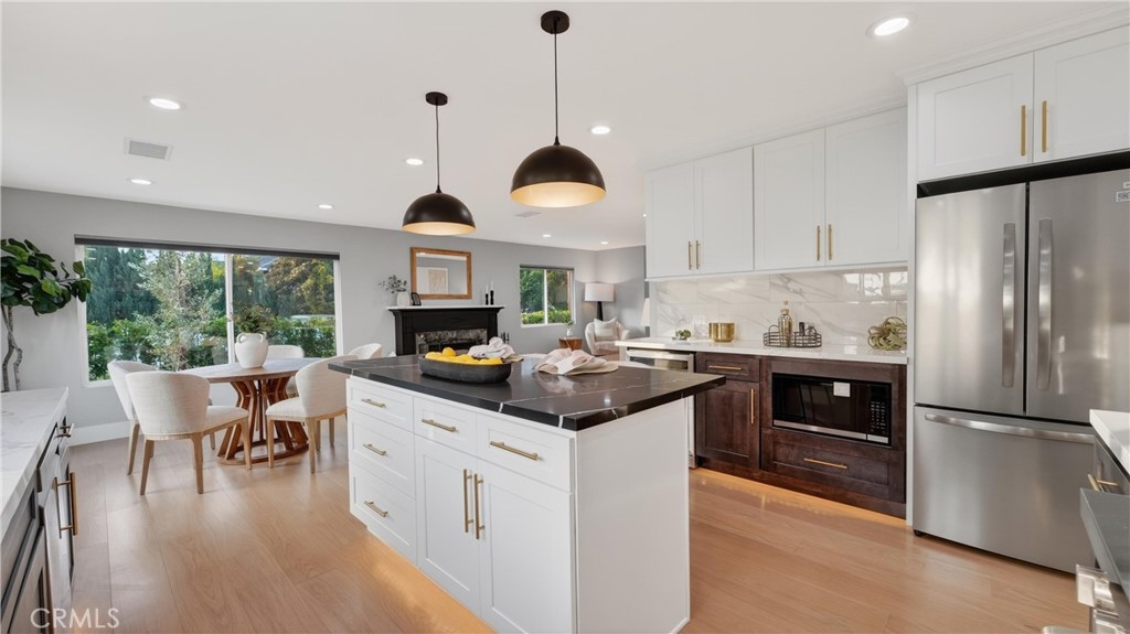 4404 Cogswell Road El Monte, CA 91732 - Photo 22 of 63 a kitchen with a stove a refrigerator a dining table and chairs with wooden floor
