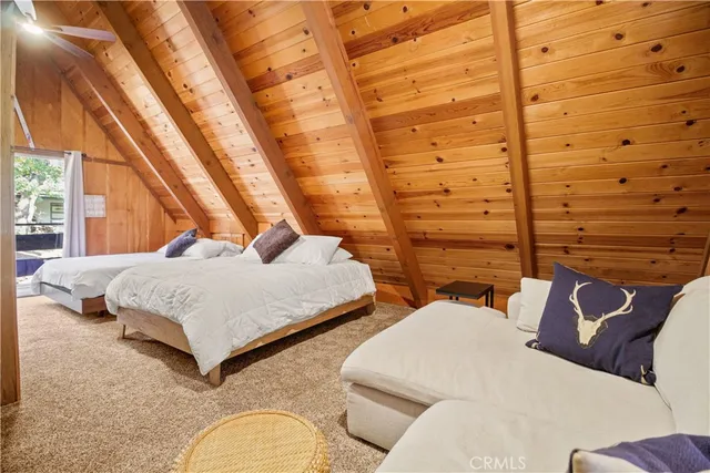 a bedroom with two beds and next to a window