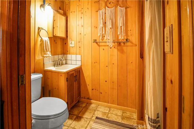 a bathroom with a sink a toilet and shower curtain