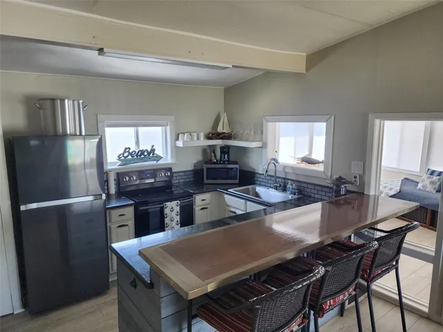 a living room with a table chairs and a refrigerator