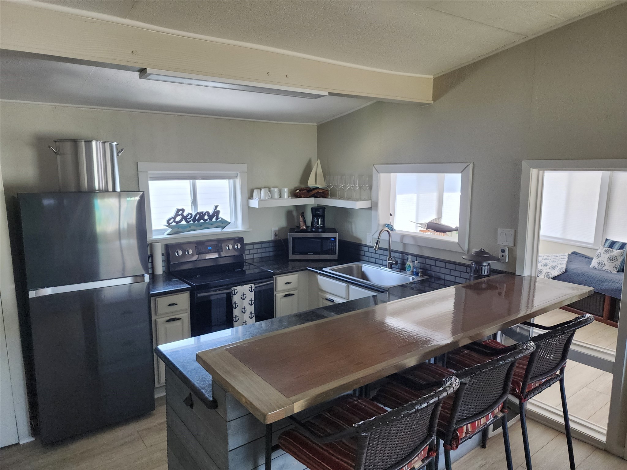 21 Tindel Street Clear Lake Shores, TX 77565 - Photo 5 of 12 a living room with a table chairs and a refrigerator