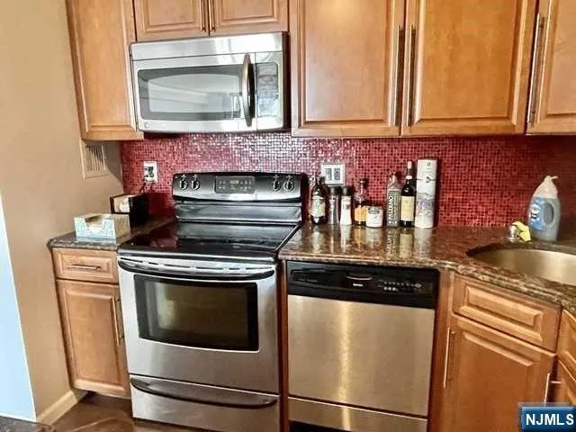 a kitchen with granite countertop a stove top oven