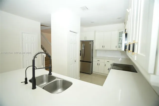 a kitchen with a refrigerator and a sink