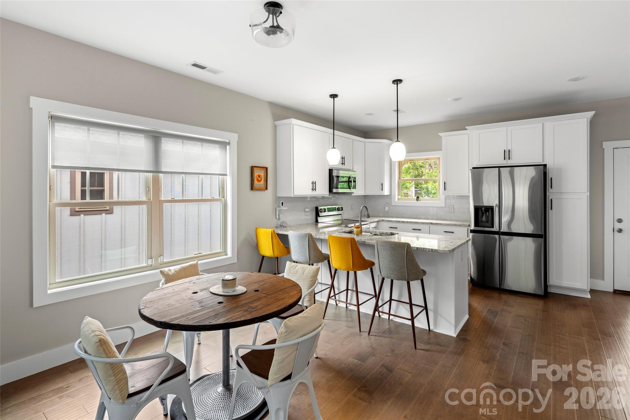 52 Wheeler Road Weaverville, NC 28787 - Photo 6 of 21 a kitchen with stainless steel appliances kitchen island granite countertop a refrigerator a stove a sink dishwasher with a dining table and chairs with wooden floor