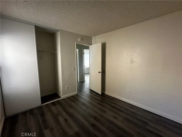 an empty room with wooden floor and closet