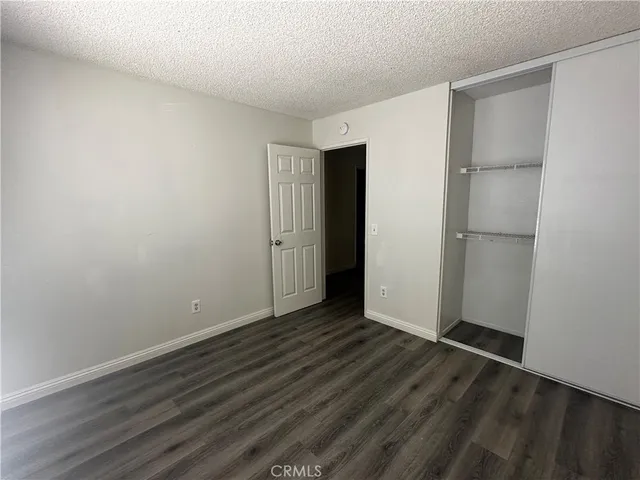 an empty room with wooden floor and closet