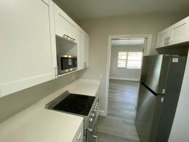 a kitchen with a sink a stove and cabinets