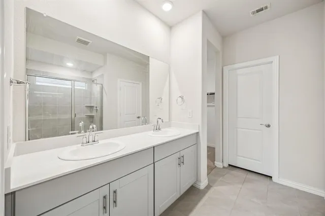a bathroom with a sink double vanity granite tub shower and a mirror
