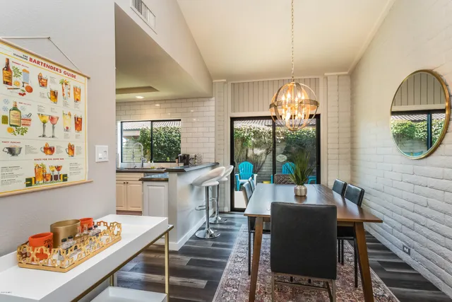 a kitchen with stainless steel appliances kitchen island granite countertop a table chairs and a refrigerator
