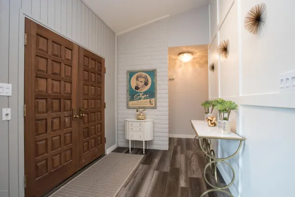 a view of a hallway with wooden floor and a dining room