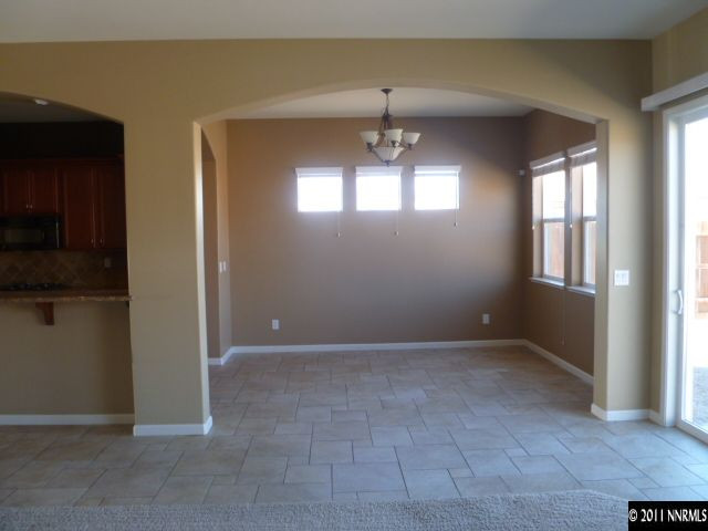 10122 Golden Spur Court Reno, NV 89521 - Photo 12 of 13 en empty room with windows and chandelier