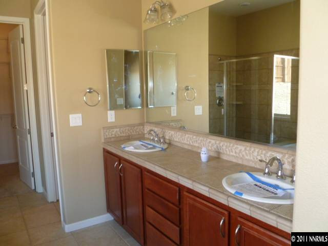 10122 Golden Spur Court Reno, NV 89521 - Photo 7 of 13 a bathroom with a granite countertop sink and a mirror