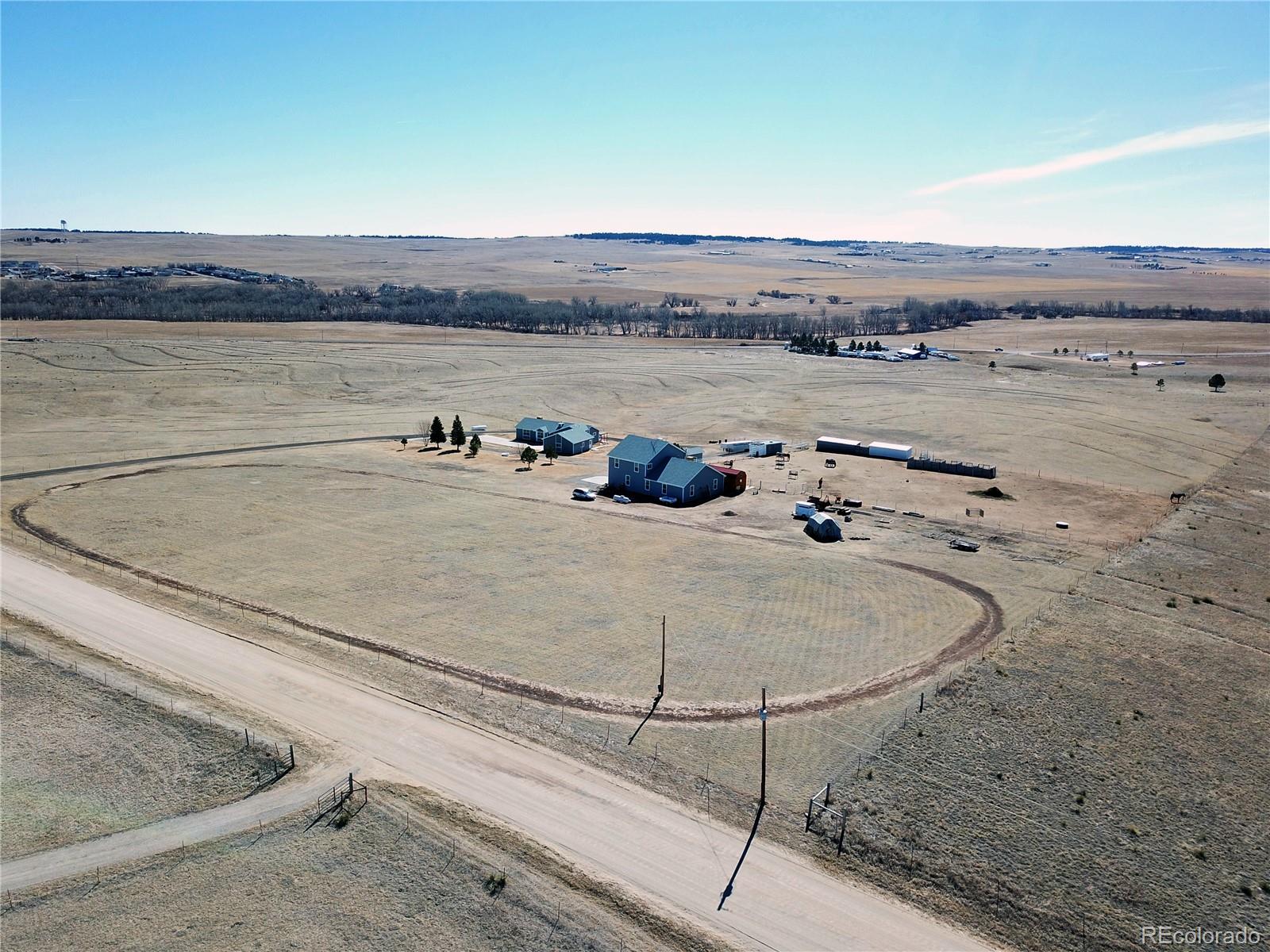 Aerial view of home, detached garage/shop and horse facilities