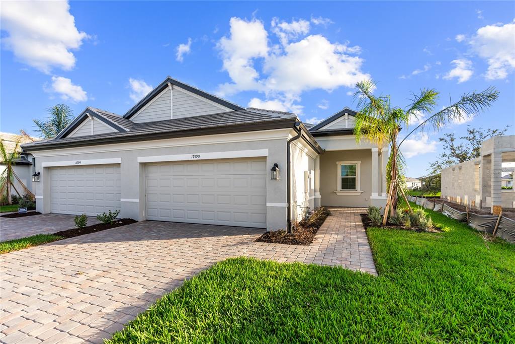 17990 Cherished Loop Bradenton, FL 34211 - Photo 1 of 1 a front view of a house with a yard and garage