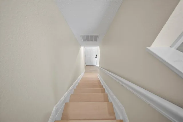 an empty room with wooden floor ceiling fan and windows