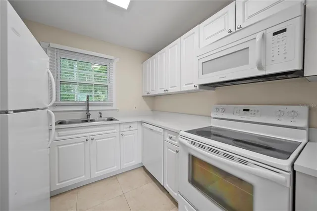 a kitchen with a sink cabinets stainless steel appliances and a window