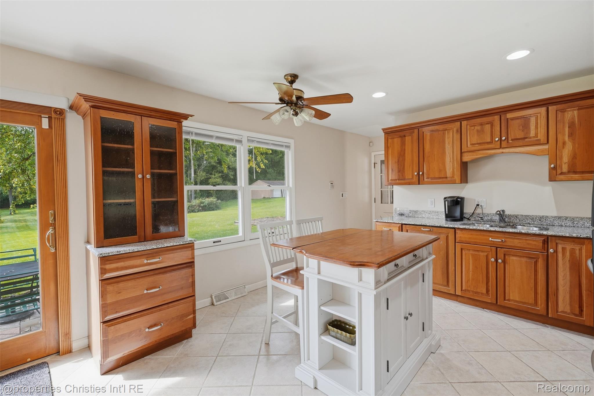 4030 Textile Road Ypsilanti, MI 48197 - Photo 16 of 58 Kitchen featuring wood cabinetry, light-toned countertops, a center island with wood surface, and tiled flooring