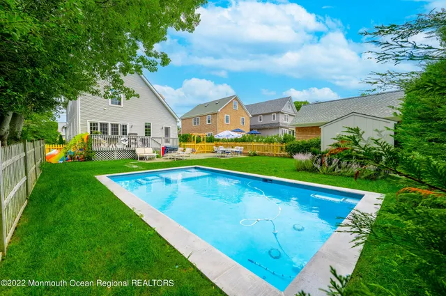 a view of an house with swimming pool and yard