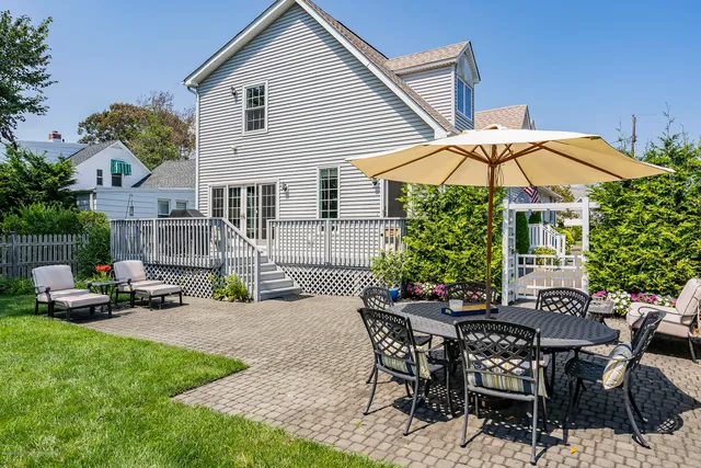 a view of a house with backyard and sitting area