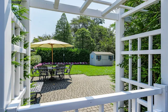 a view of a chair and table in backyard of the house