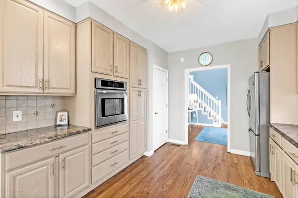 a kitchen with granite countertop a refrigerator stove and sink