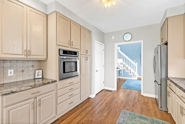 a kitchen with granite countertop a refrigerator stove and sink