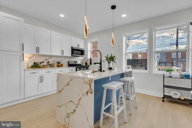 a kitchen with white cabinets and sink