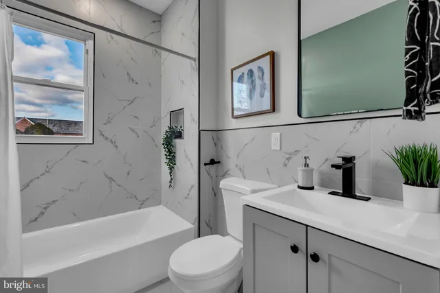 a bathroom with a sink a toilet a shower curtain and a bath tub