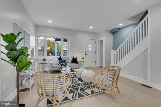 a view of a livingroom and dining room with furniture wooden floor and a potted plant