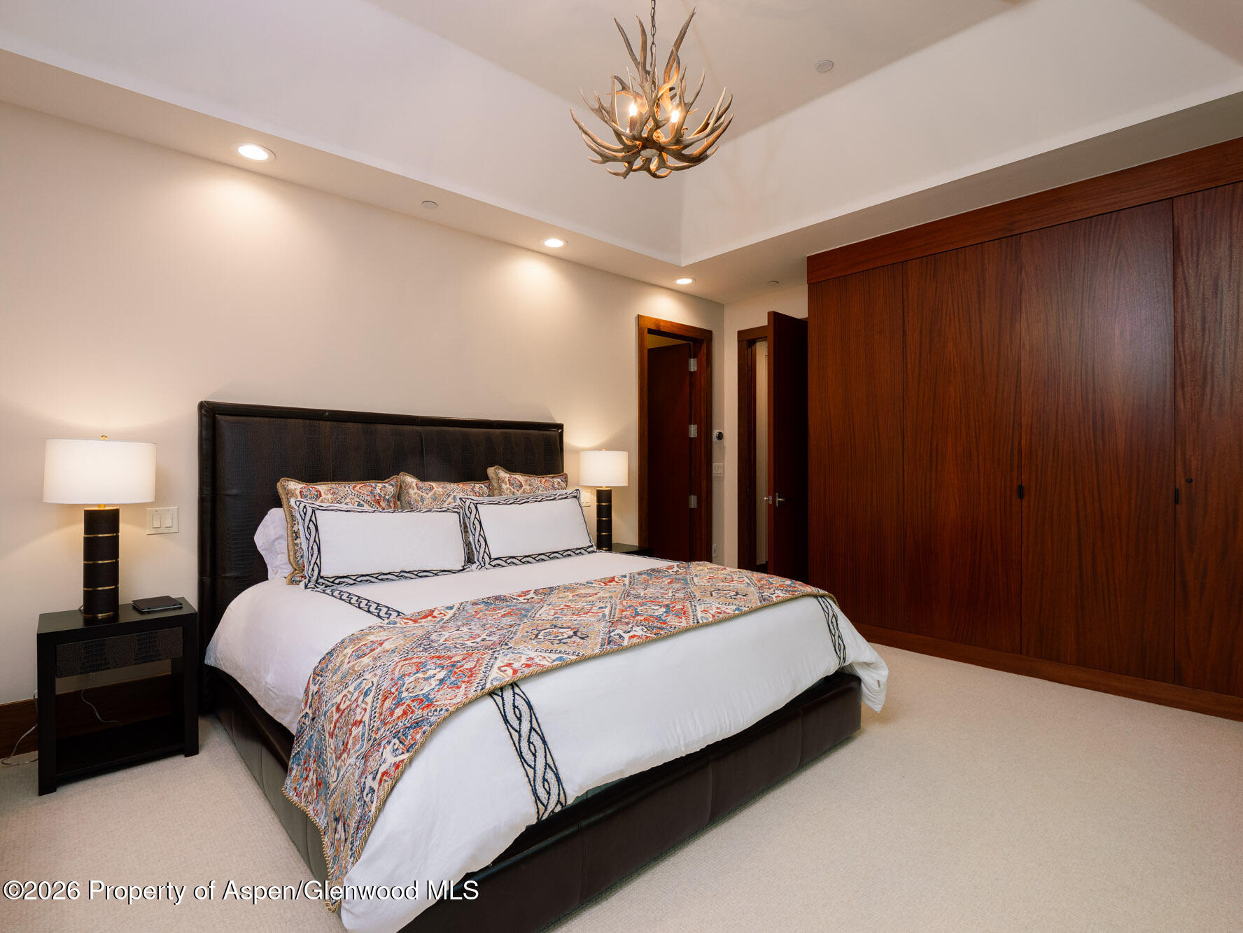 750 South Starwood Road Aspen, CO 81612 - Photo 20 of 39 a bedroom with a large bed and a chandelier