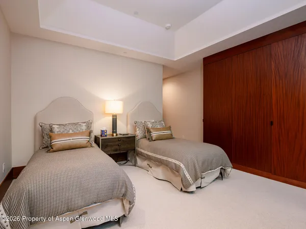 a bedroom with two bed and a night stand