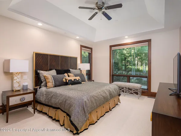 a bedroom with a bed and large windows