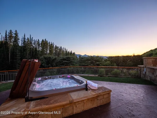 a view of a swimming pool with couches chairs and a fire pit